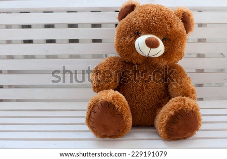 brown teddy bear on white bench
