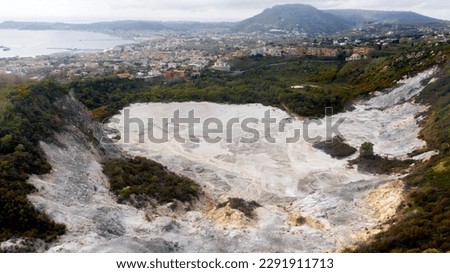 Aerial view of Solfatara of Pozzuoli, near Naples, Italy. It is a dormant volcano and part of the Phlegraean Fields volcanic area. In background there are Pozzuoli town and Mediterranean sea. Royalty-Free Stock Photo #2291911713