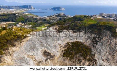 Aerial view of Solfatara of Pozzuoli, near Naples, Italy. It is a dormant volcano and part of the Phlegraean Fields volcanic area. In background there is Nisida island. Royalty-Free Stock Photo #2291912731