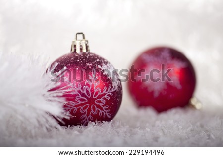 Red Christmas balls in the snow on a white background.