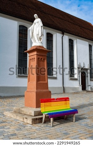 LGBTQI Rainbow Pride Bench Outdoors under a statue in front of a church