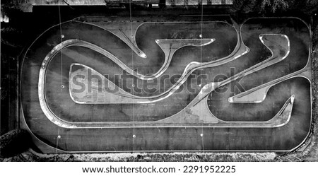 black and white aerial photo of a kart sports track. racing formulas have twisty turns and hatched asphalt edges for a better racing experience. for kids. monochrome Royalty-Free Stock Photo #2291952225