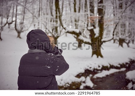 Photographer in a snowy forest in the Basque Country