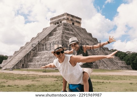 Mother and daughter happily opening their arms near the pyramid in Chichen Itza. Yucatan, Mexico Royalty-Free Stock Photo #2291969987