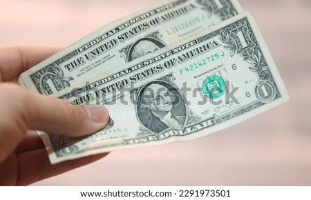 A man holding US one dollar bills. Closeup of the photograph.
