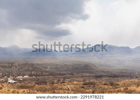 A very beautiful view of the mountains from the Sarykum sand dune, Dagestan, Russia. The stairs descend from the sand dune. A unique sandy mountain in the Caucasus on a cloudy day.