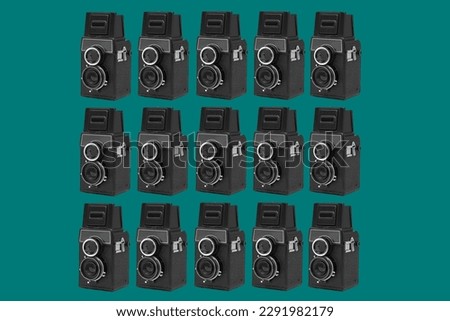 a pattern of some black retro medium format film cameras arranged in different lines on a blue background