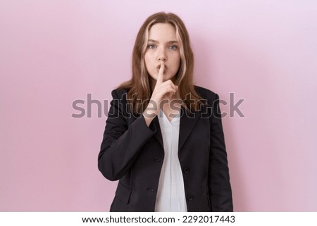 Young caucasian business woman wearing black jacket asking to be quiet with finger on lips. silence and secret concept. 