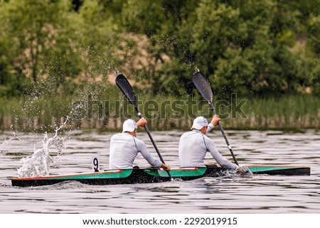side view male kayakers on kayak double in kayaking competition race, water splashes from paddles Royalty-Free Stock Photo #2292019915