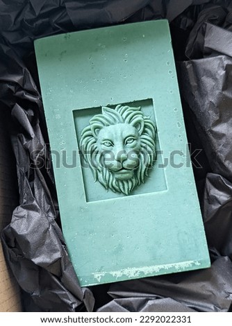 Totem monumental handmade candle with lions head bas-relief closeup Royalty-Free Stock Photo #2292022331