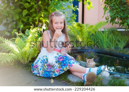 Sweet girl with cherries in the garden