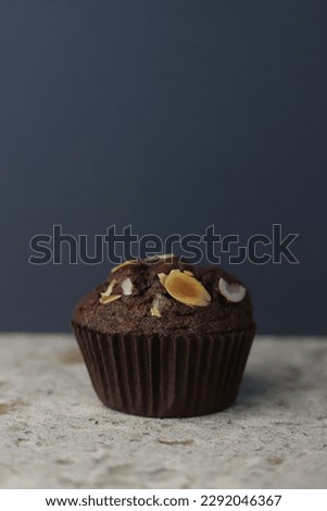 fragrant homemade
chocolate cupcake with walnuts on a dark background. for banners, postcards, napkins, flyers, business cards, screensavers, stickers, etc.