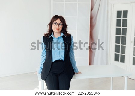 female teacher stands at a desk in a classroom in a school teaching office