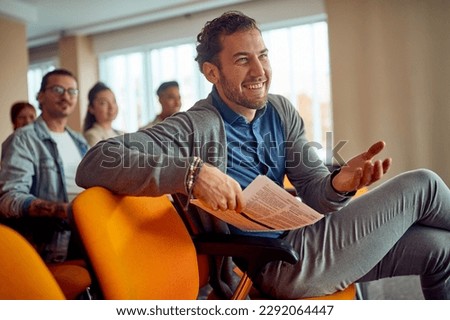Young male participant is having a pleasant conversation with a lecturer during a business lecture in a relaxed atmosphere in the conference room. Business, people, company Royalty-Free Stock Photo #2292064447