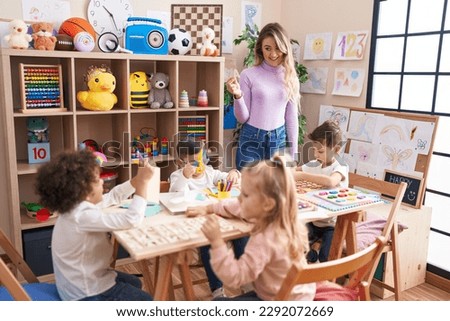 Woman and group of kids having vocabulary lesson at kindergarten Royalty-Free Stock Photo #2292072669