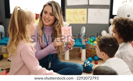 Woman and group of kids having vocabulary lesson with word cards at kindergarten Royalty-Free Stock Photo #2292072793