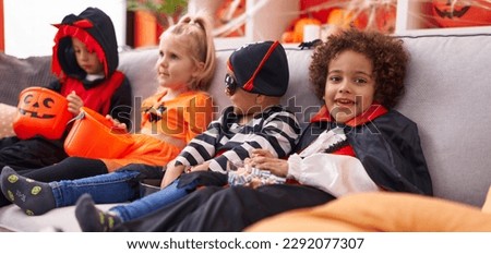 Group of kids wearing halloween costume sitting on sofa at home
