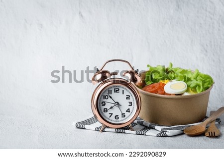 Fresh healthy salad with an alarm clock for the concept of food, time management, diet and heathy eating concept Royalty-Free Stock Photo #2292090829