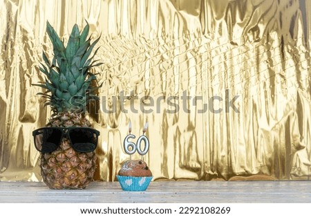Cheerful pineapple in glasses festive happy birthday character with number  60. Beautiful background for congratulations Koiya space on a golden shiny background. Anniversary congratulations