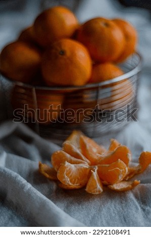 peeled tangerine on a light tablecloth next to the basket