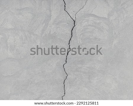 Cracked concrete surface covered with gray cement mortar. Destruction after the earthquake. Rough winding cracks on the wall. copy space. Texture background Royalty-Free Stock Photo #2292125811