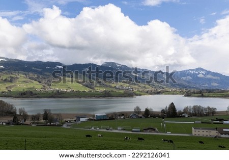 picture of a mountainous landscape in Switzerland covered with snow and partly in the clouds with Greyerzersee