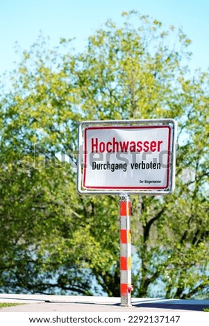Flood high tide notice info sign on the sidewalk blocked, as a warning info board in German, German language 