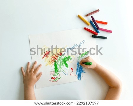 small child draws with pastel crayons on white table. fathers day Royalty-Free Stock Photo #2292137397