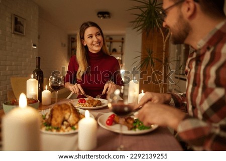Beautiful couple having romantic dinner with candles and red wine at home Royalty-Free Stock Photo #2292139255