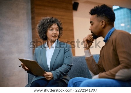 Financial advisor consulting African American man while going through his documents on a meeting in the office. Royalty-Free Stock Photo #2292141997