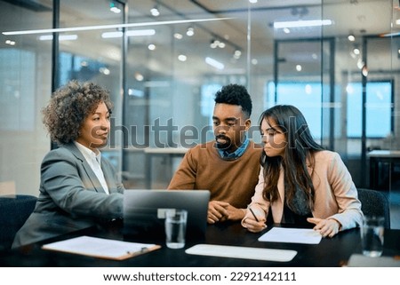 Female bank manager using laptop during a meeting with African American couple in the office.  Royalty-Free Stock Photo #2292142111