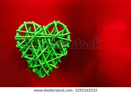 Wooden wicker heart. Rattan work in the shape of a heart. Love concept. Background with selective focus and copy space. On colored foil.