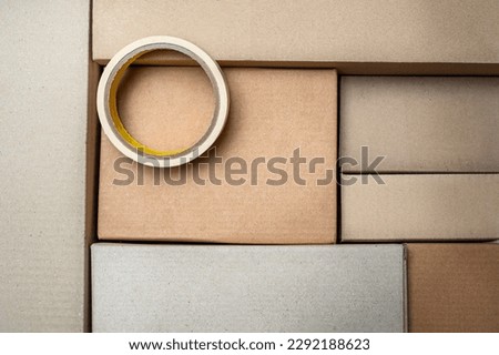 Sticky tape on a lot of cardboard boxes background. Moving, delivery