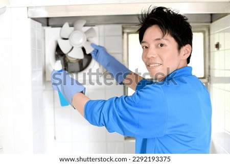 A male worker in the cleaning industry cleaning the ventilation fan Royalty-Free Stock Photo #2292193375