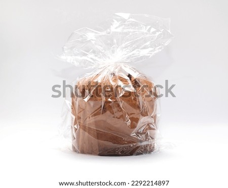 Isolated Panettone Italian Christmas Cake In Cellophane, Package On White Background. Fruitcake, Sweet bread, Originally From Milan, Italy. Pastry Dessert. Horizontal plane. High quality photo Royalty-Free Stock Photo #2292214897
