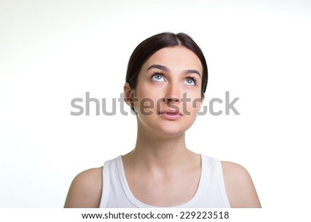 Beautiful young woman daydreaming over white background