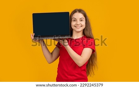 cheerful kid with laptop on yellow background