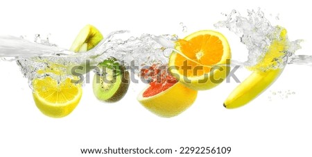 Fresh fruits falling in water with splash on a white background. Splashing fruit on water.