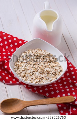 Oat flakes for breakfast on white wooden table. Selective focus.