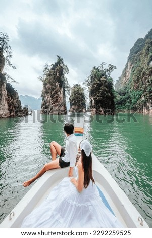 Couple riding a long tail boat to Khao Sok National Park, Phang Nga Province Khao Sok National Park with a long tail boat for tourists Cheow Lan Lake Ratchaprapha Dam on holiday Royalty-Free Stock Photo #2292259525