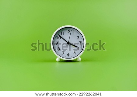 alarm clock on green background time concept working with time precious time
