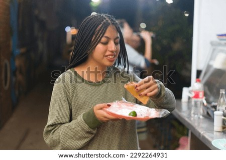 Woman eating mexican street food 