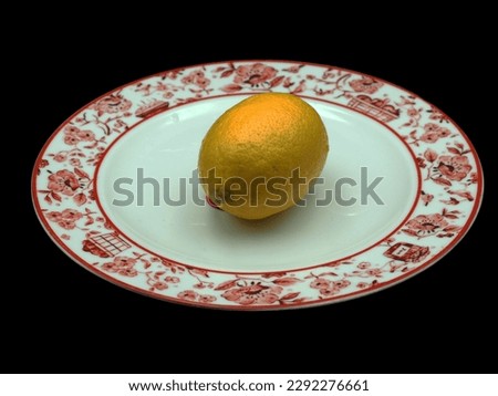 Lemon in white porcelain plate on black background