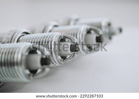 Car service. A set of new car spark plugs as a spare part of motor vehicles on white. Group of candles for the motor close-up