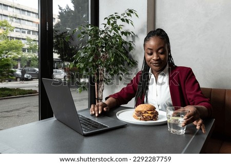 Busy young professional business woman wearing suit using laptop computer sitting in cafe restaurant. Hungry manager remote working online thinking on online marketing operations or elearning