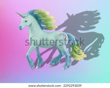 Blue unicorn toy and shadow on a pastel background 