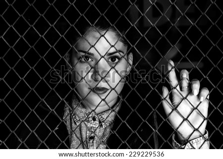 Locked female behind metal wire,black and white technique and selective focus