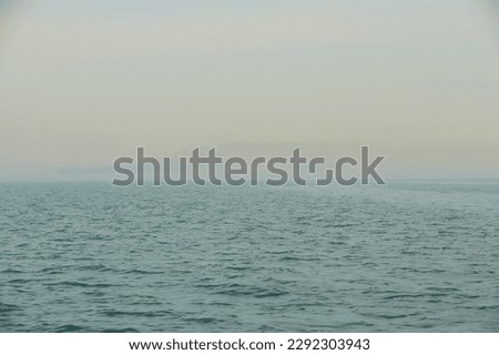 The sea in the fog. The line of the horizon, dissolving in the fog with blurred sun. Irish sea in fog. Foggy weather 