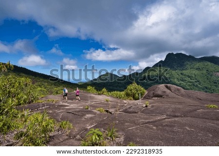 Copolia trail, couple heading back down the nature trail,view of morn blanc an morn Seychellois, Mahe Seychelles 1 Royalty-Free Stock Photo #2292318935
