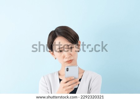 Asian businesswoman with a smartphone on blue background